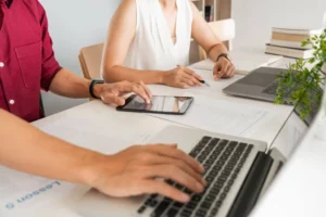 a man and woman working on a laptop