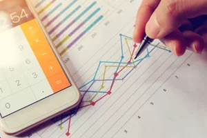 a person holding a pen over a graph