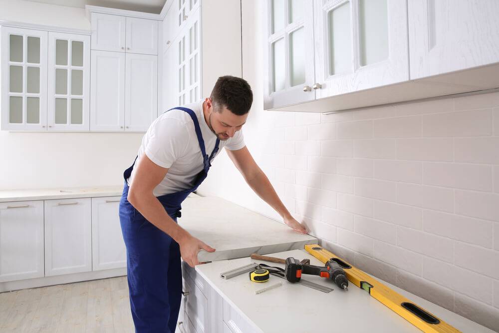 a man in overalls measuring a counter
