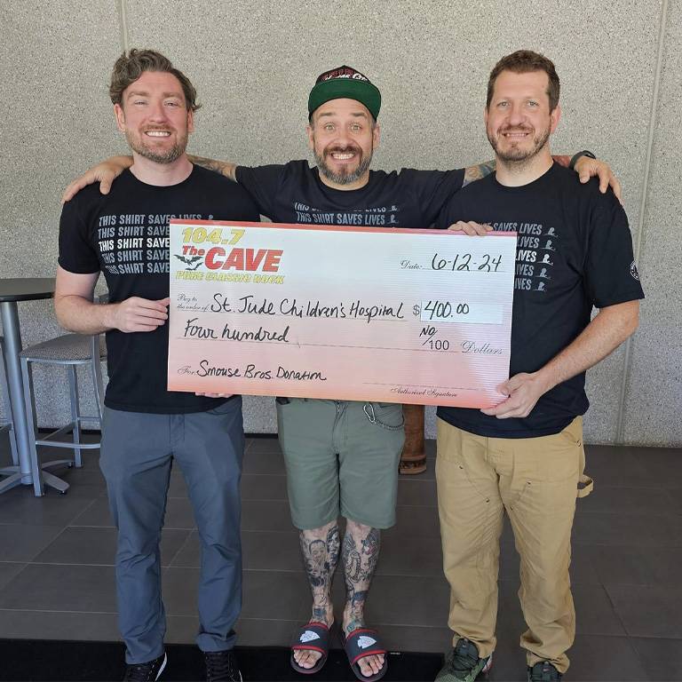 a group of men holding a large check