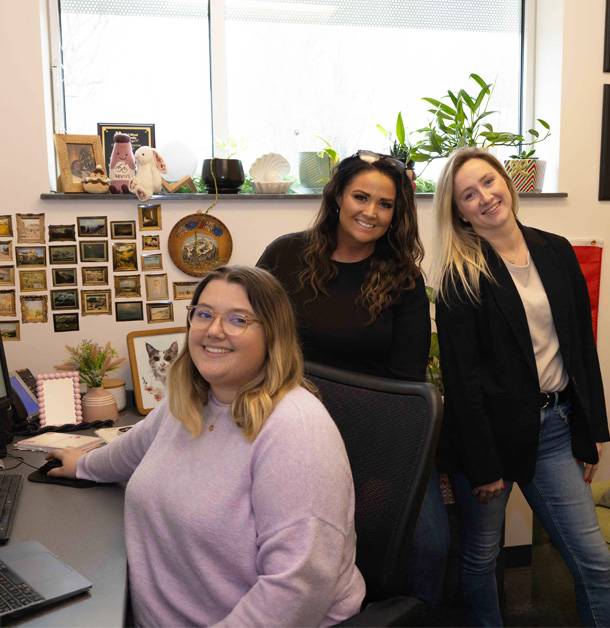 a group of women smiling at a computer