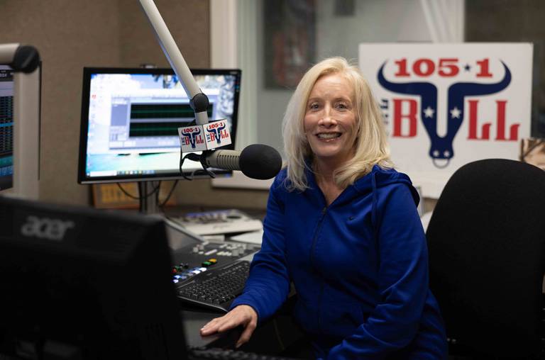 a woman sitting in front of a microphone