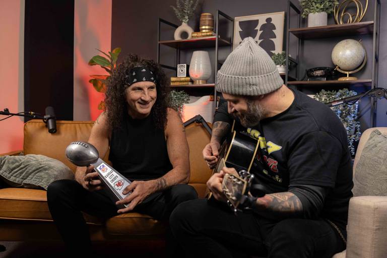 a man playing a guitar and holding a trophy