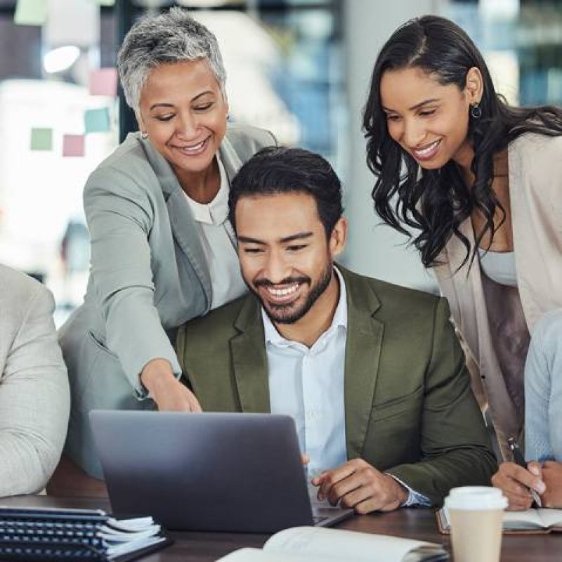 a group of people looking at a laptop
